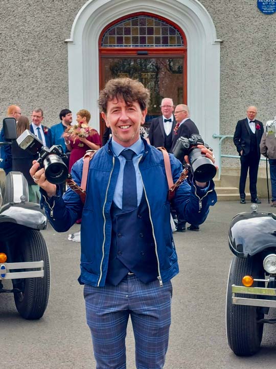 photographed leaving the church on a wedding day Coleraine photographer Paul Davis pictured with his cameras